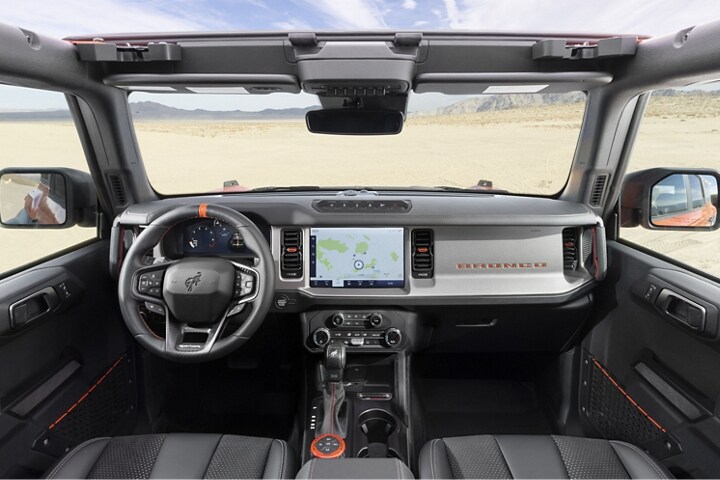 Toma desde el interior de una Ford Bronco® Raptor® 2023 enfocando hacia el desierto que se encuentra más allá del parabrisas