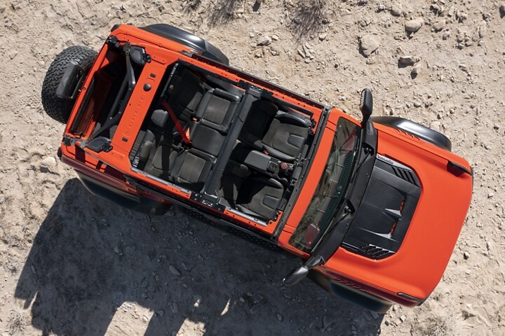 Vista superior de una Ford Bronco® Raptor® 2023 de cuatro puertas en Code Orange estacionada en el desierto sin el techo