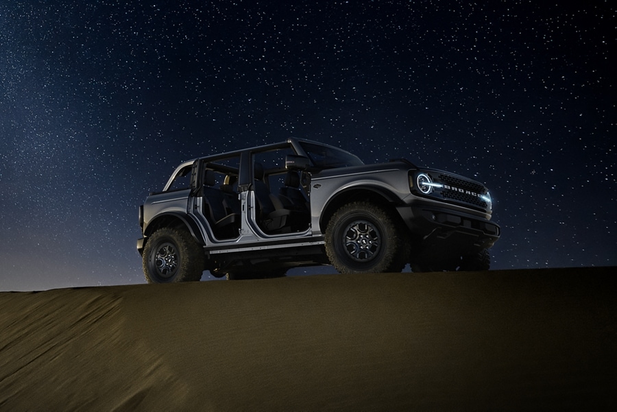 Una Ford Bronco® Badlands® 2023 en Carbonized Gray Metallic estacionada en la naturaleza al atardecer