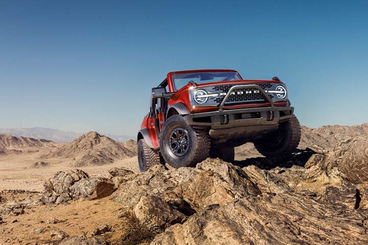 Una Ford Bronco® Wildtrak® 2023 de cuatro puertas en Race Red con defensa delantera modular disponible y cabestrante WARN®
