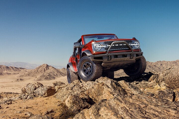 Four-door 2023 Ford Bronco® Wildtrak® in Race Red with available modular front bumper and WARN® winch