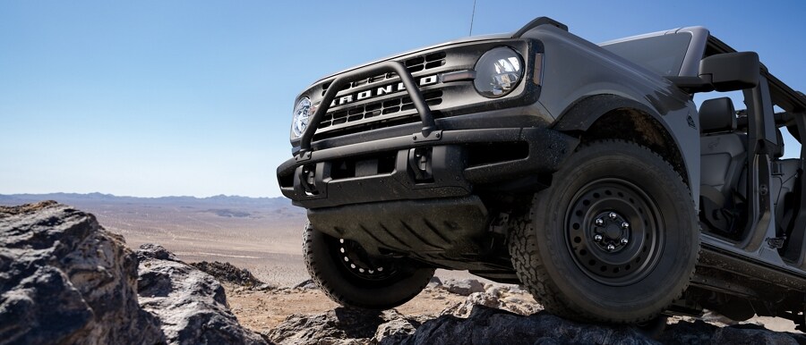 Una Ford Bronco® Black Diamond® 2023 en Carbonized Gray Metallic andando por un terreno escabroso