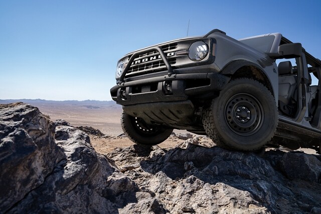 Una Ford Bronco® Black Diamond® 2023 en Carbonized Gray Metallic andando por un terreno escabroso