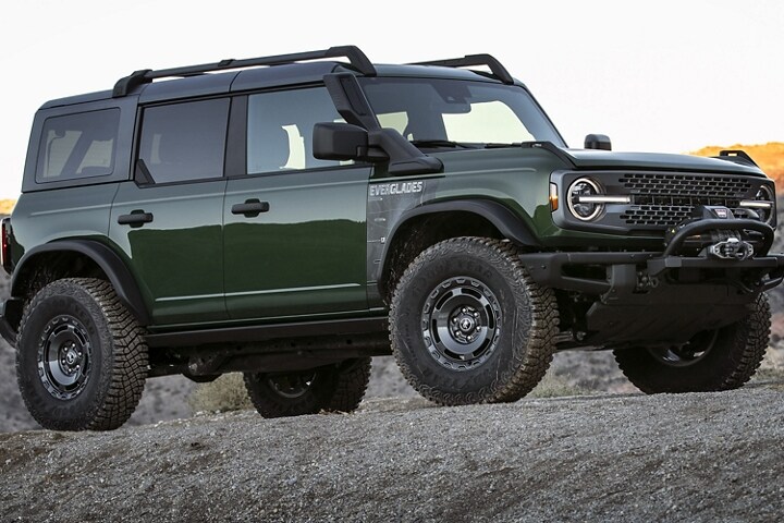 Una Ford Bronco® Everglades™ 2023 de cuatro puertas en Eruption Green Metallic estacionada en un camino
