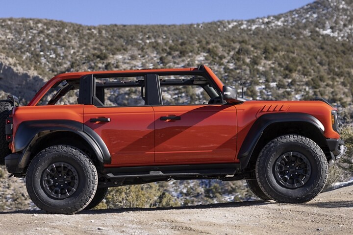 Una Ford Bronco® Raptor® 2023 de cuatro puertas en Code Orange estacionada en el desierto