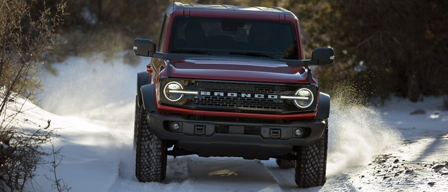 Una Ford Bronco® Wildtrak® 2023 andando por terreno escabroso en un sendero cubierto de nieve