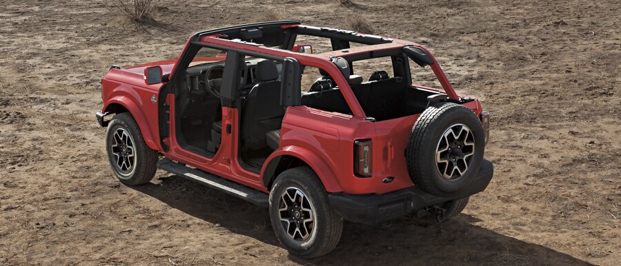 Se muestra el modelo Ford Bronco® Outer Banks® 2023 de cuatro puertas en Race Red sin el techo duro ni las puertas