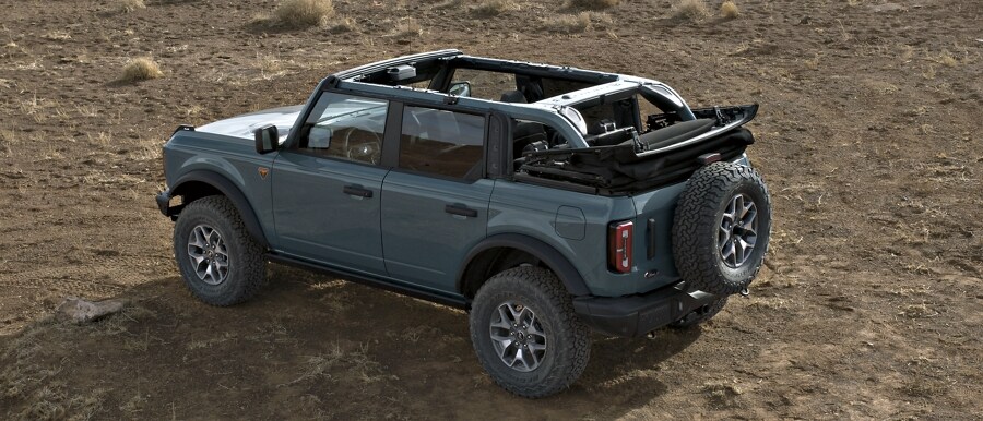 Se muestra el modelo Ford Bronco® Badlands® 2023 de cuatro puertas en Azure Gray con el techo blando completamente abierto