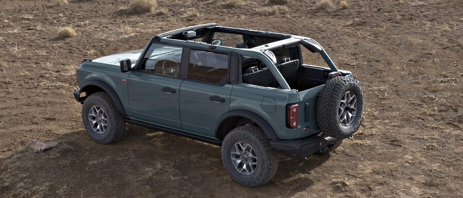 Se muestra el modelo Ford Bronco® Badlands® 2023 de cuatro puertas en Azure Gray con el techo blando retirado por completo