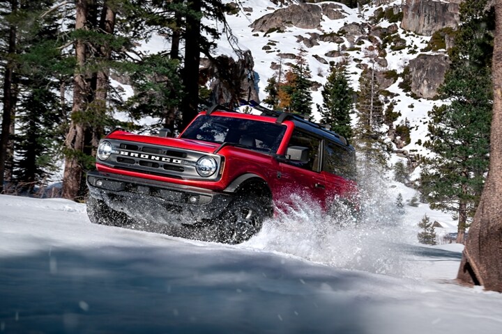 Una Ford Bronco® Big Bend® 2023 de dos puertas en Race Red andando por la nieve