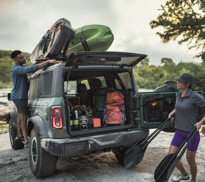 A 2023 Ford Bronco® Black Diamond® being packed up with kayaks mounted on the roof rack