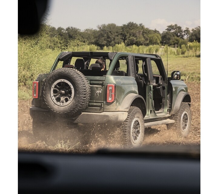 A 2023 Ford Bronco® Badlands® with doors removed and top off being driven off-road