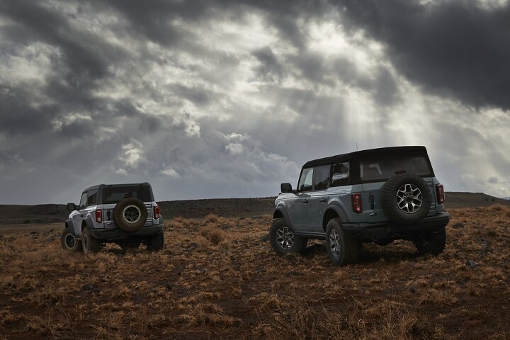 Una Ford Bronco® Badlands® 2023 de dos y cuatro puertas andando por el desierto
