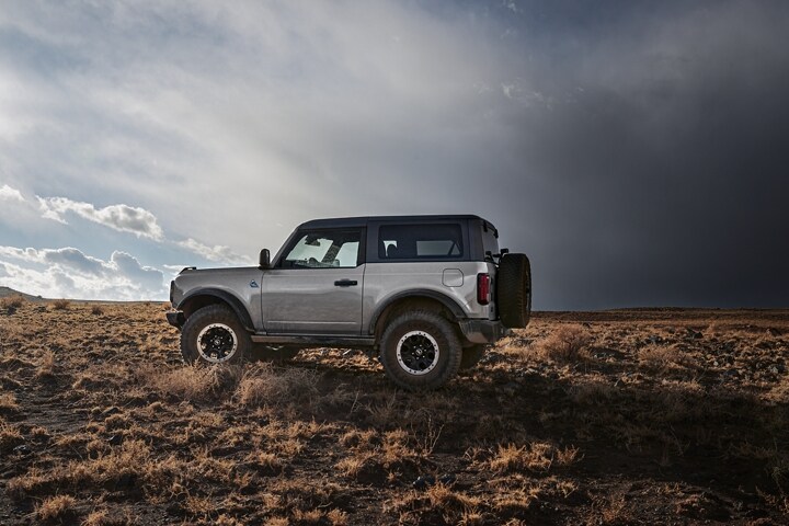2023 Ford Bronco® Badlands® in Iconic Silver being driven off-road with an available two-door hardtop