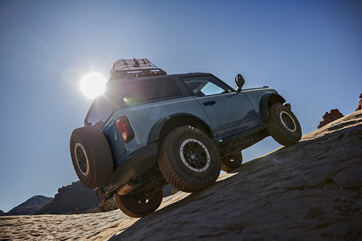 Una Ford Bronco® Black Diamond® 2023 de dos puertas en Azure Gray trepando por un terreno escabroso
