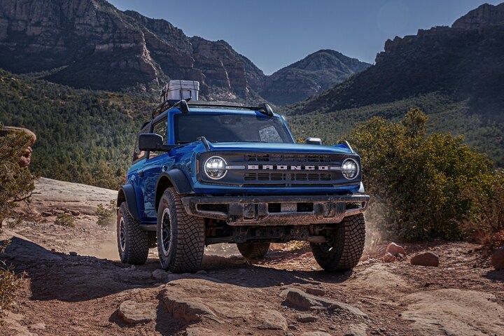 Una Ford Bronco® Black Diamond® 2023 de dos puertas en Velocity Blue con Accesorios Ford disponibles andando por un camino
