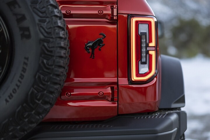 Close-up of taillamp and logo of 2024 Ford Bronco® Wildtrak® in Race Red
