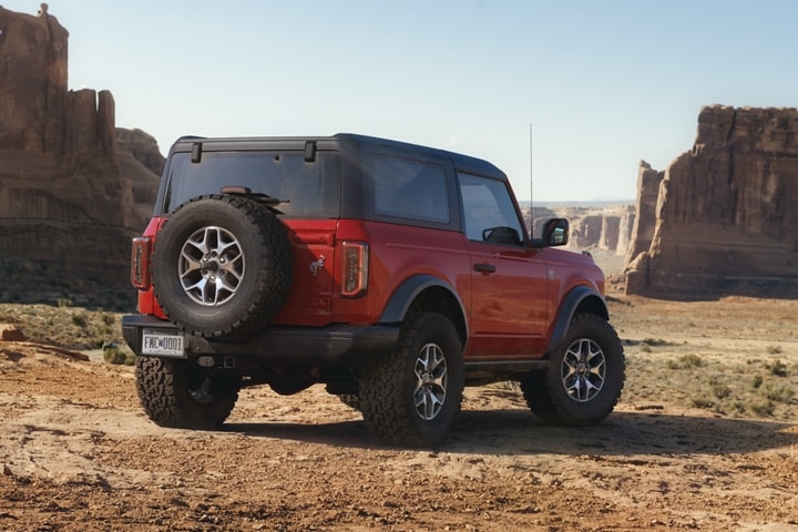 Two-door 2024 Ford Bronco® Badlands® in Race Red parked in the rocky wilderness