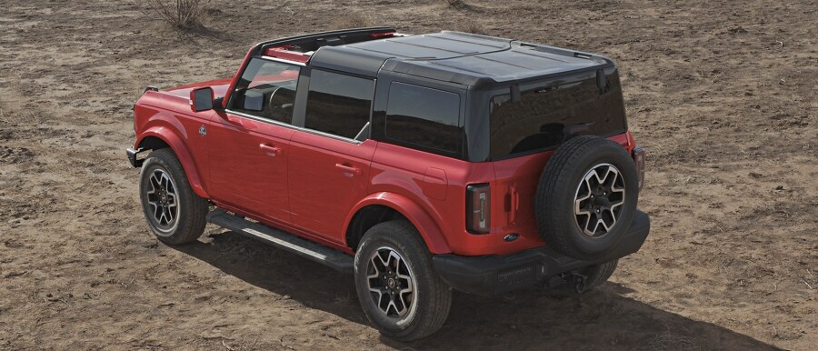Four-door 2024 Ford Bronco® Outer Banks® model shown in Race Red with hardtop partially removed