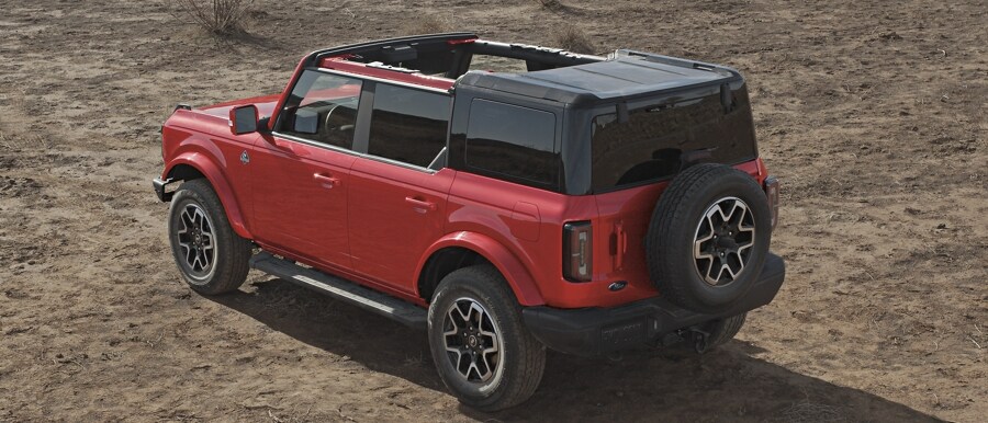 Four-door 2024 Ford Bronco® Outer Banks® model shown in Race Red with hardtop half removed