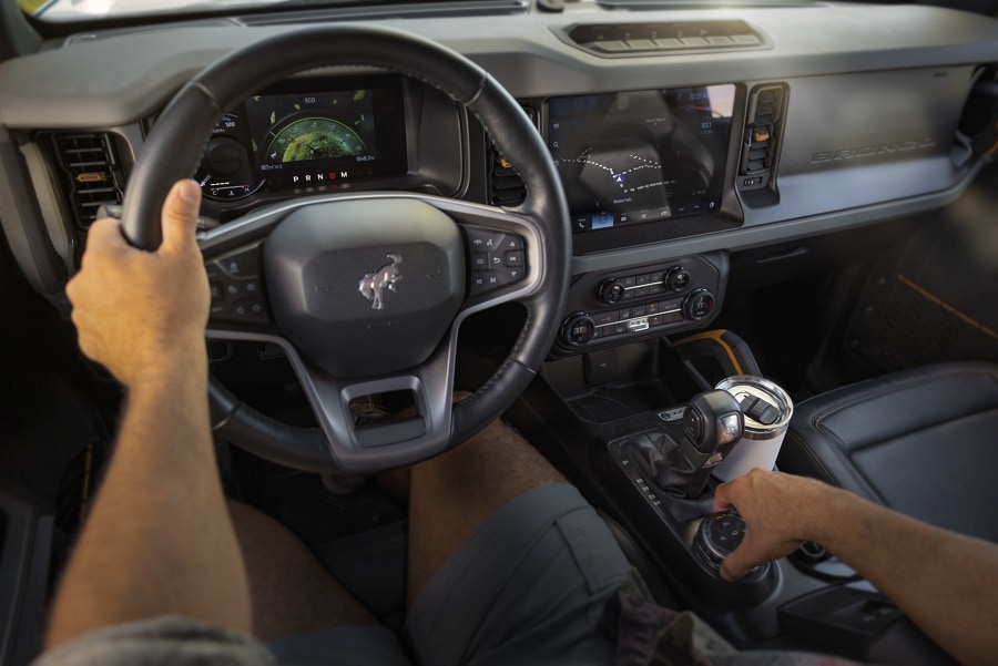 Interior of a 2024 Ford Bronco® as the driver switches gears and we see the dashboard