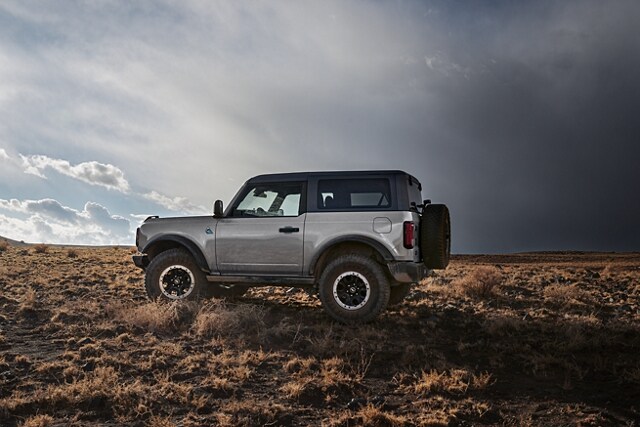 Two-door 2024 Ford Bronco® Black Diamond™ in Iconic Silver parked in the wilderness