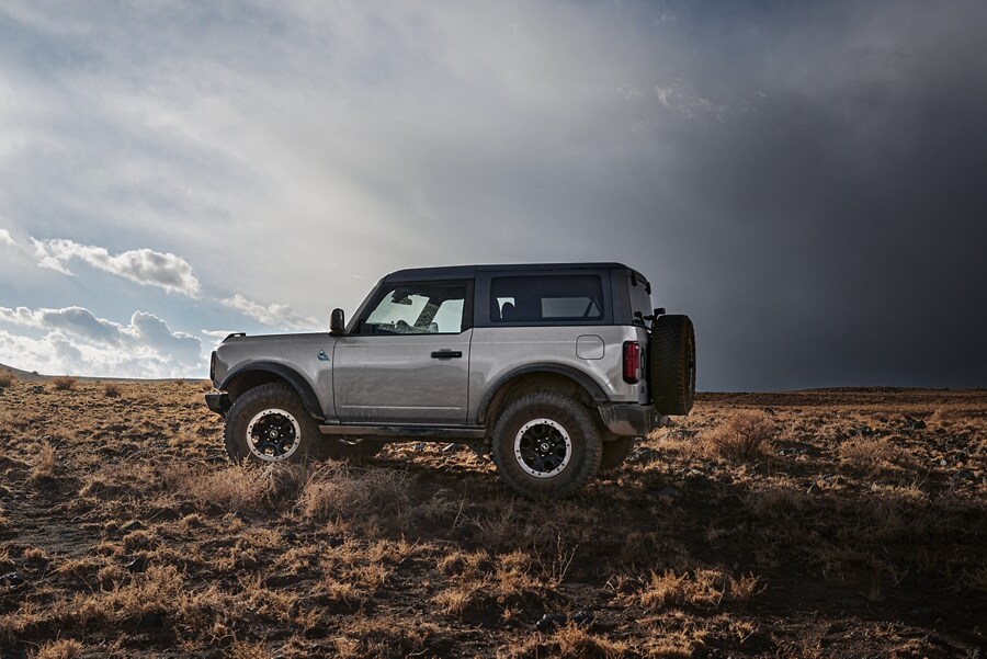 Two-door 2024 Ford Bronco® Black Diamond™ in Iconic Silver parked in the wilderness