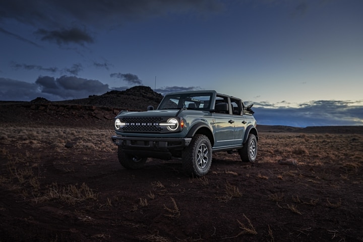 Four-door 2024 Ford Bronco® Badlands® in Azure Gray parked in the desert at dusk