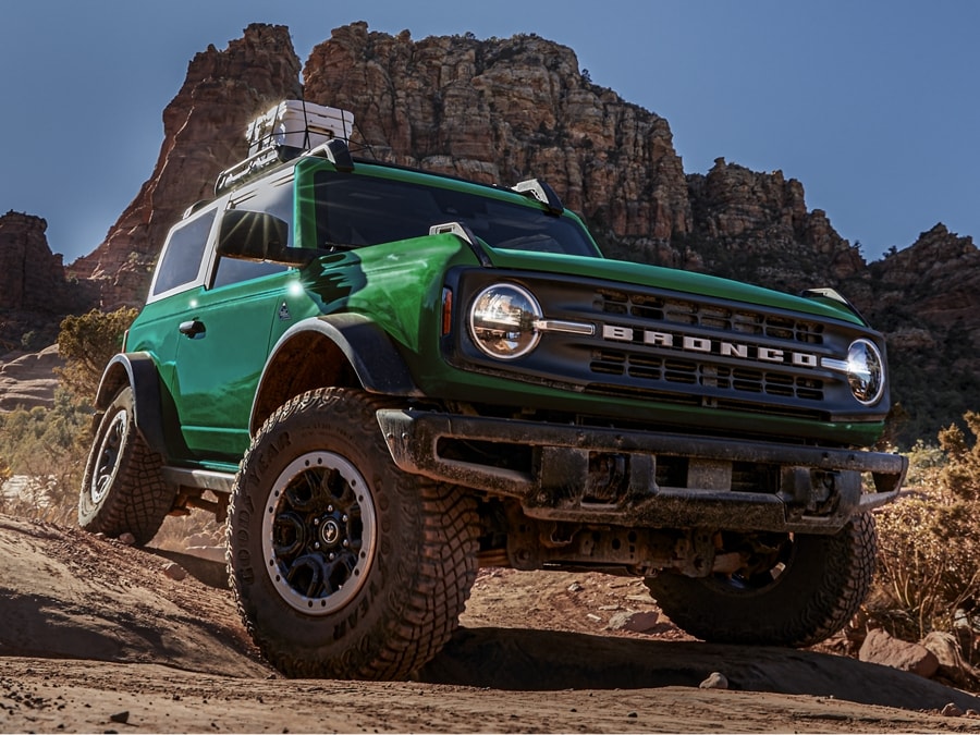 A 2024 Ford Bronco® two-door being driven over a trail in a canyon