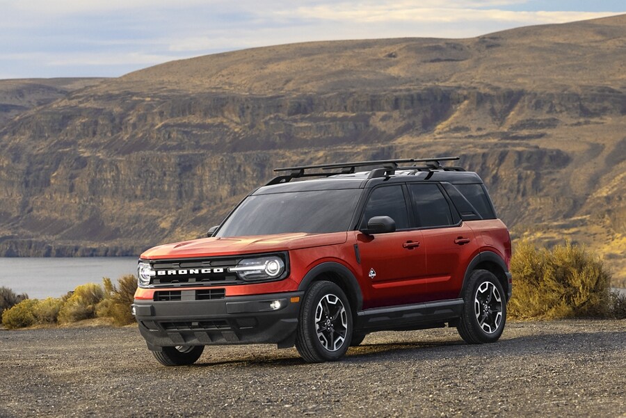 Una SUV Ford Bronco® Sport 2023 estacionada cerca de un lago con montañas de fondo