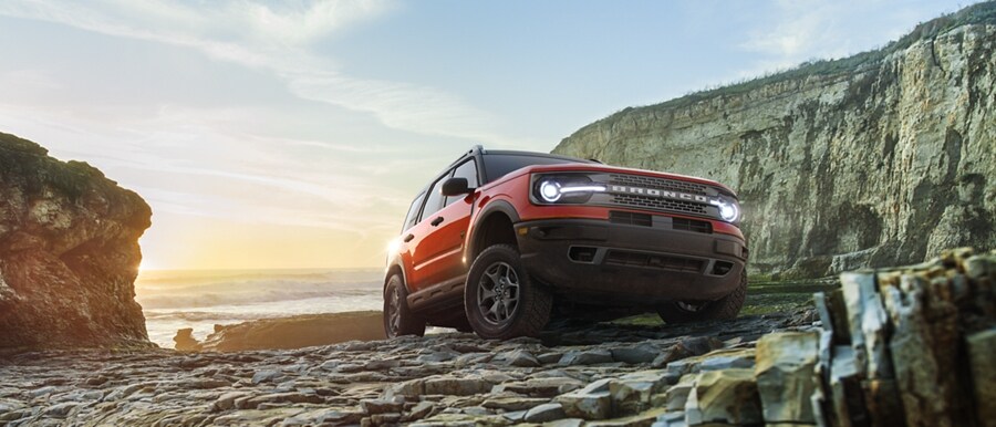Una Ford Bronco® Sport estacionada sobre rocas con acantilados de fondo