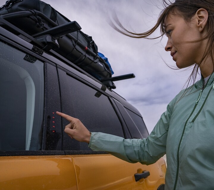 Woman pushing keypad while standing outside of her 2023 Ford Bronco® Sport SUV