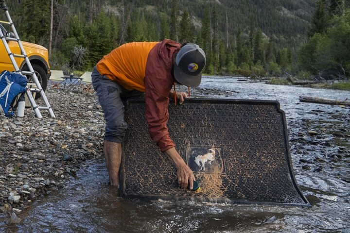 Un hombre en un río lavando el tapete para carga de su SUV Ford Bronco® Sport 2023