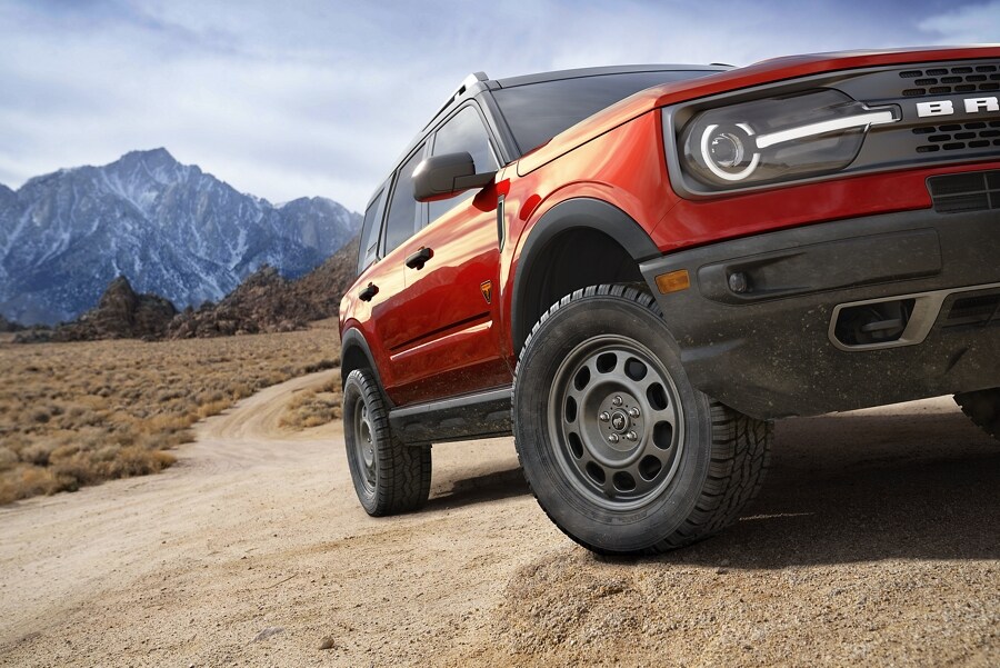 Imagen de tres cuartos de la SUV Ford Bronco® Sport 2023 estacionada en un camino de tierra con montañas de fondo