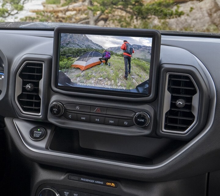 Man sitting in the driver’s seat looking at the backup camera