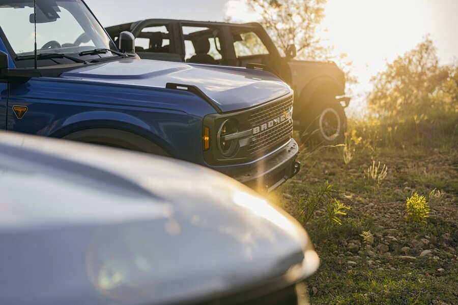 Varios vehículos Bronco® estacionados sobre el césped con las puertas desmontadas
