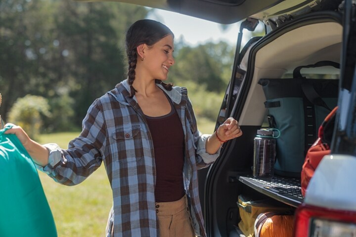 Se muestra una Ford Bronco® Sport 2023 con carga en la parte trasera mientras una niña sostiene una bolsa de dormir