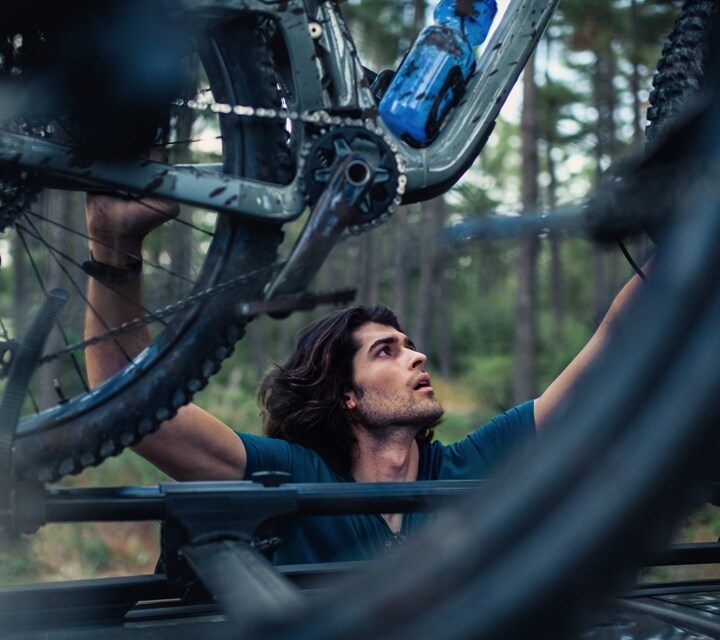 A man is securing his bike to the roof of the 2024 Ford Bronco® Sport