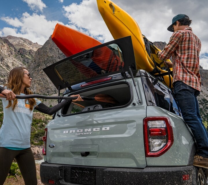 2024 Ford Bronco® Sport shown with rear-flip up glass with two people loading gear into vehicle