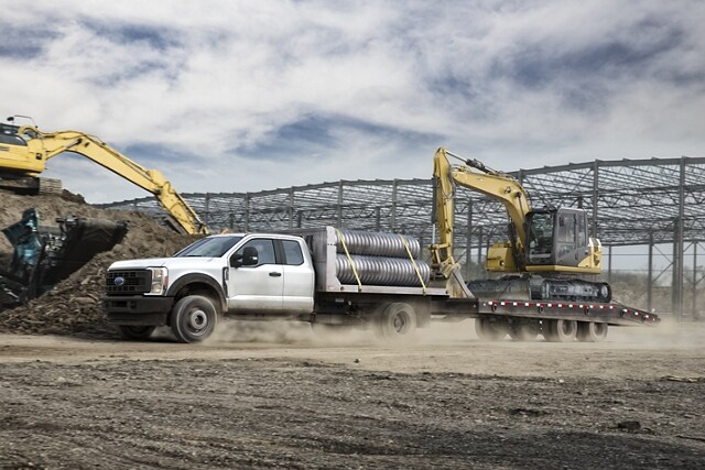 2023 Ford Super Duty® Chassis Cab with upfit being driven around curved mountain road while towing cargo