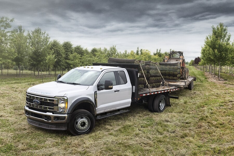 2023 Ford Super Duty® XLT model parked in an orchard with equipment loaded on the flatbed