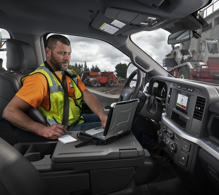 Trabajador usando una laptop dentro de una Ford con Chasis con Cabina Super Duty® 2023