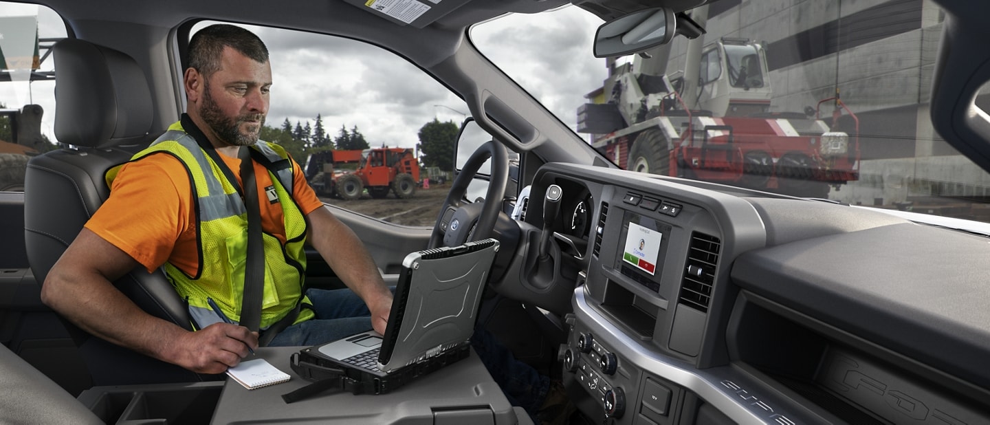 Worker using laptop inside a 2024 Ford Super Duty® Chassis Cab