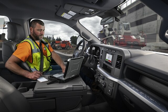 Worker using laptop inside a 2024 Ford Super Duty® Chassis Cab