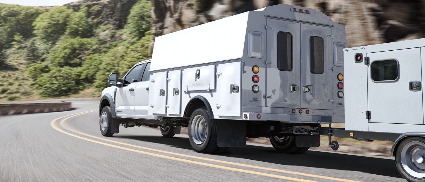 2024 Ford Super Duty® Chassis Cab with a flatbed uplift hauling dirt and cement debris