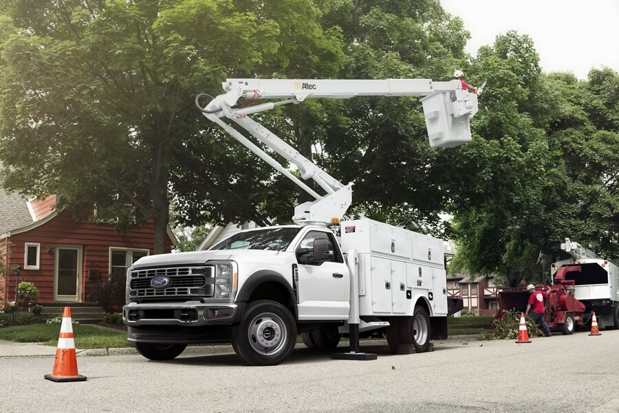 2024 Ford Super Duty® Chassis Cab shown with bucket upfit with a tree-trimmer cutting trees