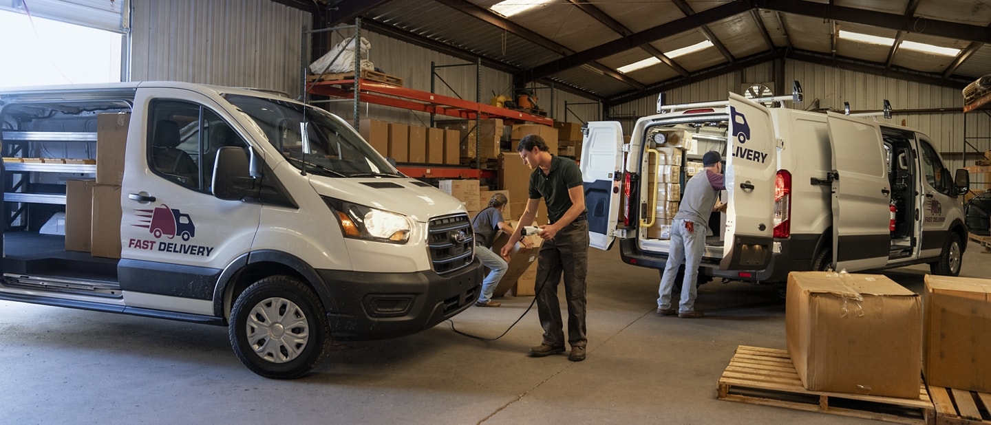 Man standing in front of a 2023 Ford E-Transit™ with a power tool