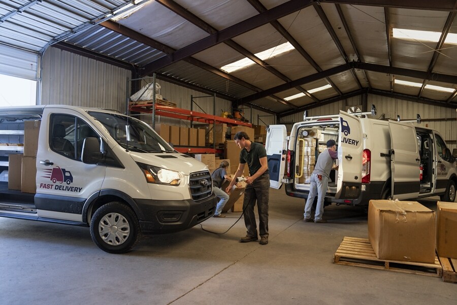 Un hombre parado frente a una Ford E-Transit™ 2023 con una herramienta eléctrica