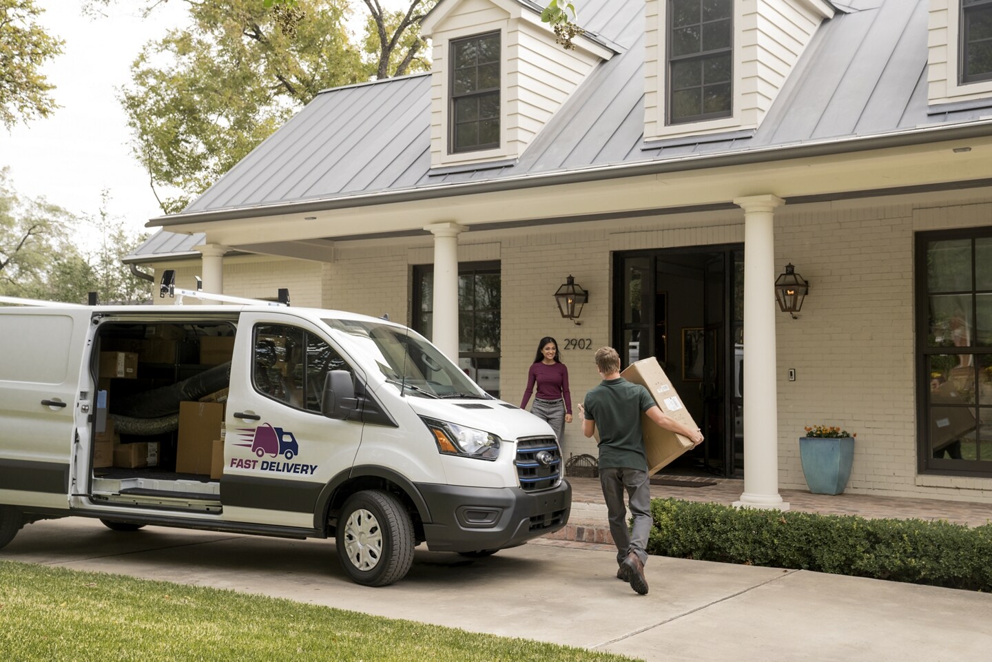2024 Ford E-Transit delivering a package to a household.