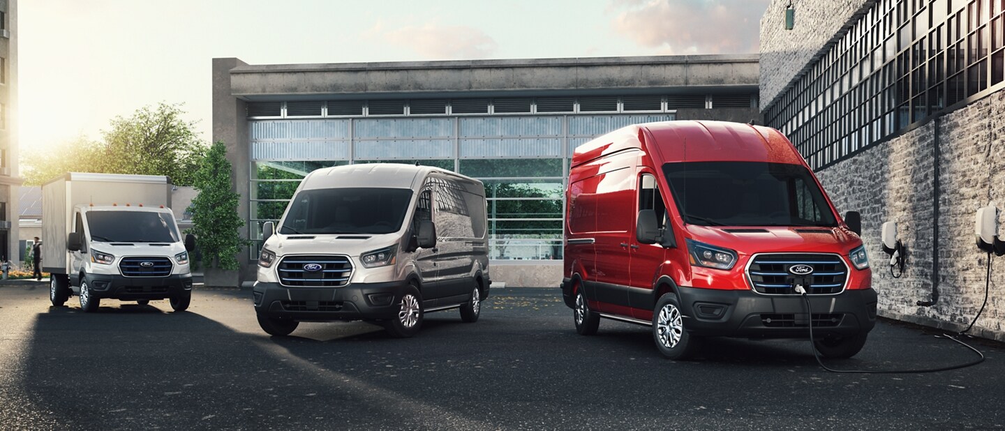 Ford E-Transit chassis cab and cargo van parked by charging station